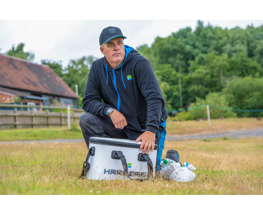 Hoodie, Cap, Uhr, Kühlbox, Mann im Feld